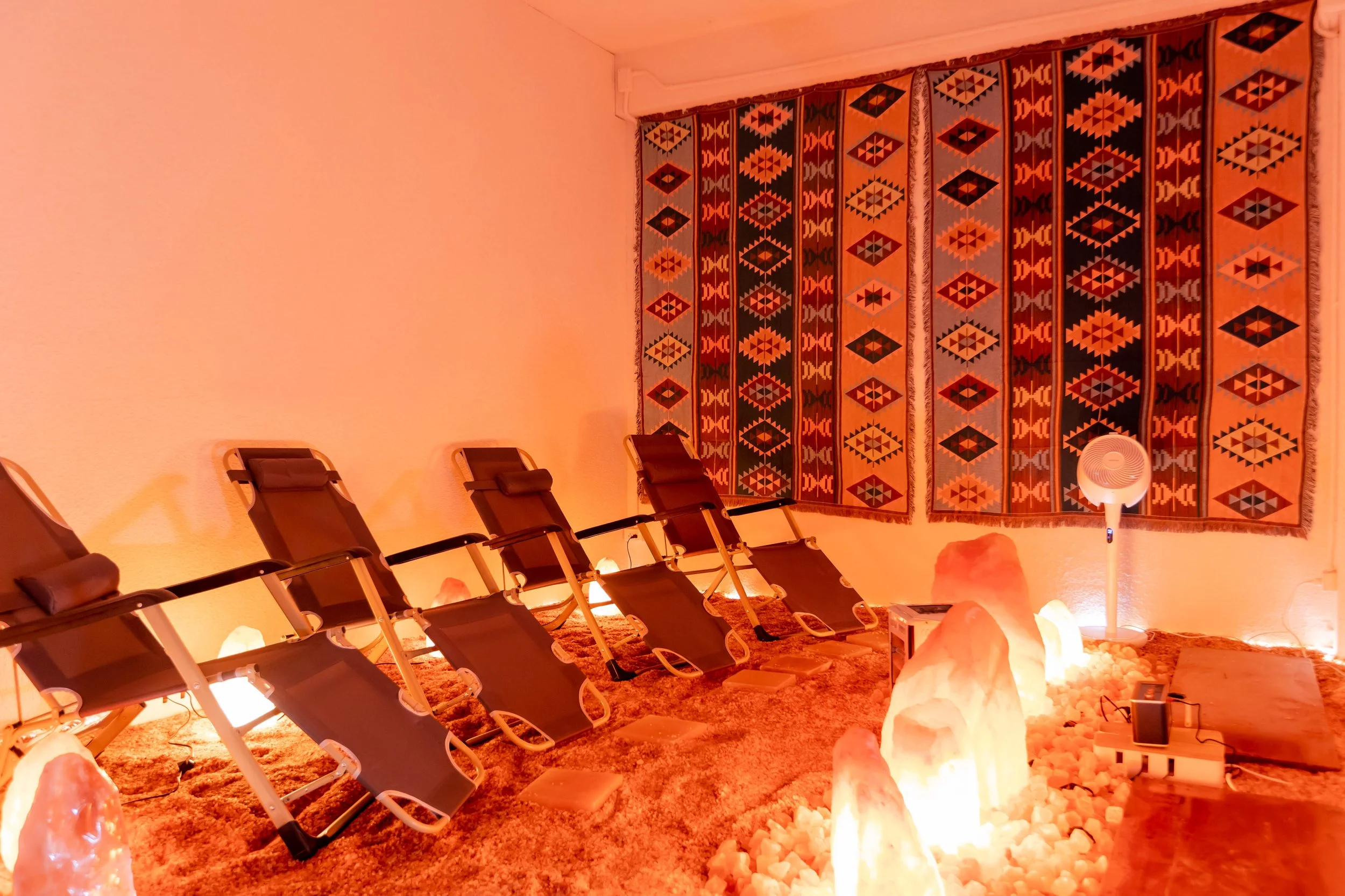 Himalayan salt room with glowing salt lamps and loungers at Maxwell Onsen Bangkok