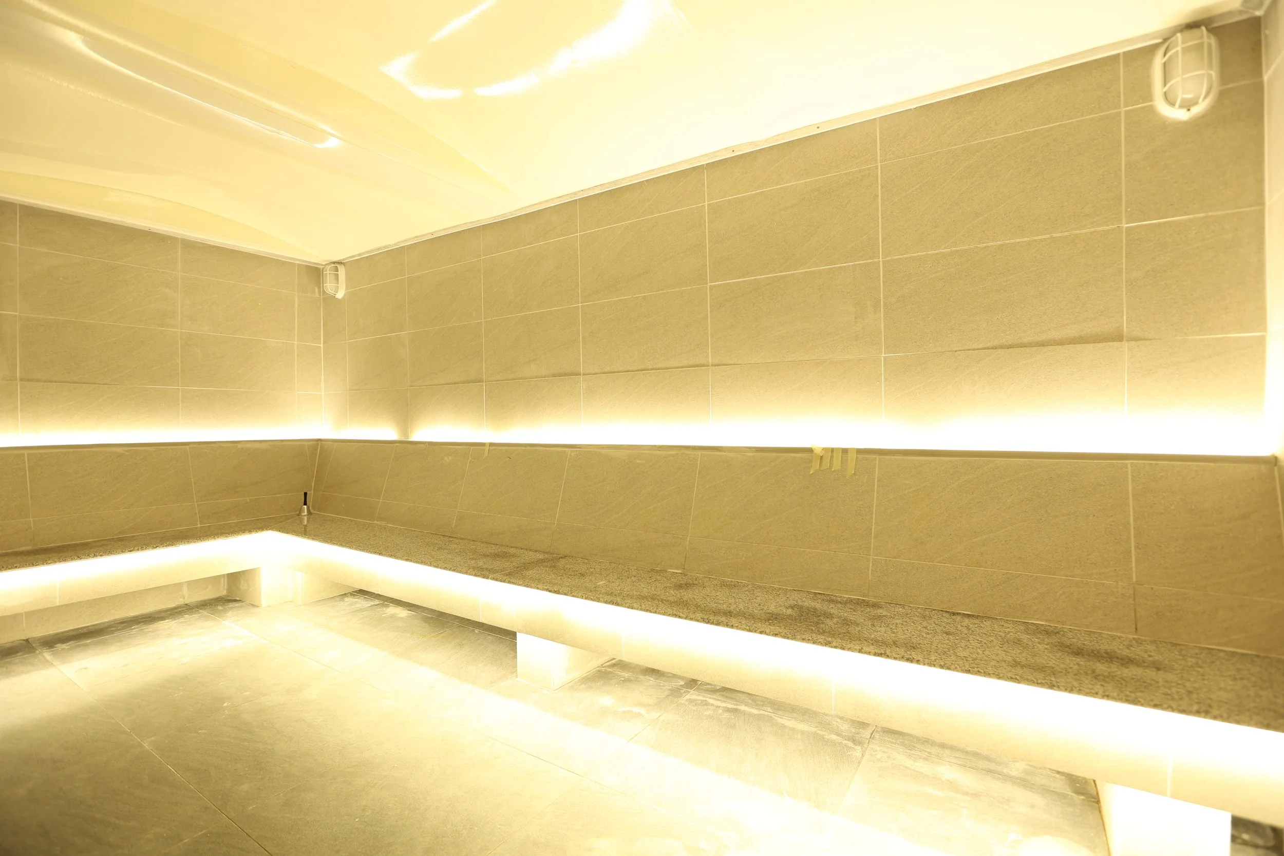 Stone steam room with under-lit benches at Maxwell Onsen gay onsen Bangkok